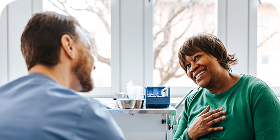 Man and woman sitting down and looking at a laptop